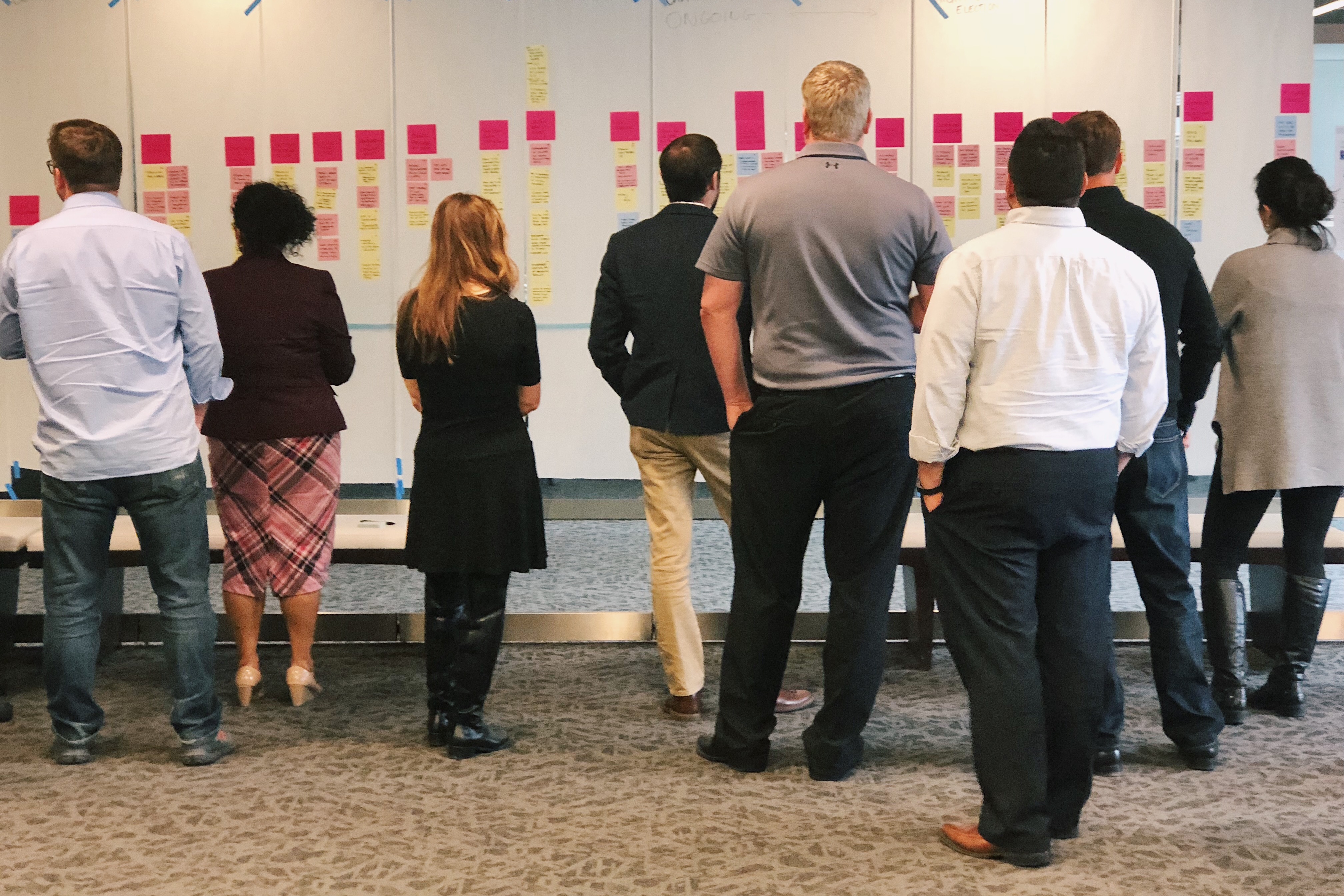 Election officials looking at multi-colored sticky notes organized on posters